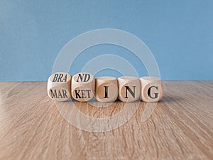 Branding and marketing symbol. Turned wooden cubes and changes the word Marketing to Branding. Beautiful wooden table, blue