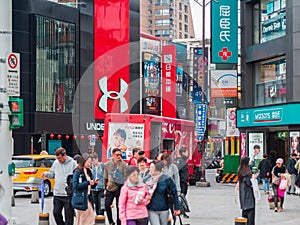 Brandname shops at Ximending Youth Shopping District, The `Harajuku` of Taipei with a group of tourist in foreground.