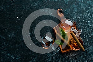 Brandy in glasses and cigars on a black stone table. Top view.