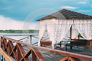 Braslaw, Vitebsk Voblast, Belarus. Seagull Gull Bird Sitting Near Wooden Arbor In A Wooden Pier For Fishing And Rest