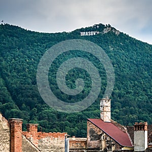 Brasov written with big letters on Mount Tampa. Brasov sign with old roofs and chimneys in the