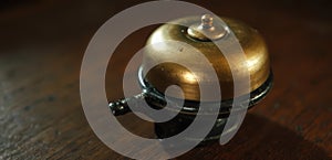 A brass bell sitting on top of a wooden table