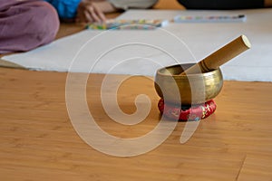 Brass bowl on the cloth base lay on the wood floor. It`s the Asian vintage gimmick to ring a signal and sound for notice the