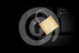 Brass closed padlock on a black keyboard