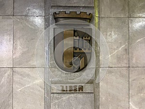 The brass coat of arms of the Liben district of Prague in the subway at Palmovka.