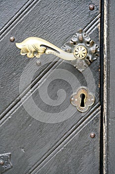 Brass door knob of a grey door