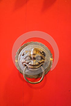 Brass Door Knocker on the red door of the temple