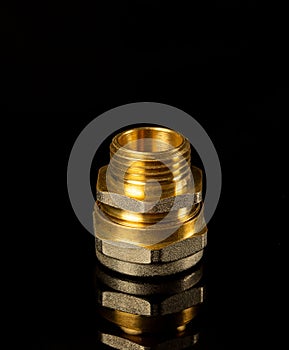 Brass fitting on a black background. Often used in plumbing and gas installations