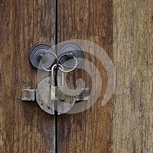 Brass lock hanging on door ring knobs