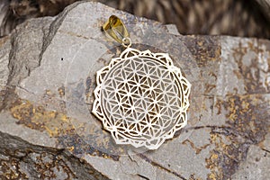 Brass metal pendant on natural background