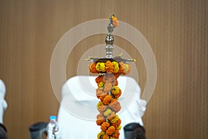 A brass oil lamp decorated with yellow and orange marigold flowers for inauguration lamp lighting ceremony