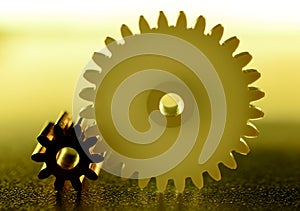 Brass and plastic gears engaged with the yellow backlight on a dark background.