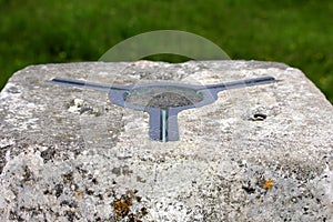 The brass plate used as a mounting point for a theodolite on top of a concrete British Ordnance Survey triangulation point, or Tri