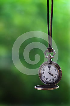 Brass pocket watch hanging from a leather rope