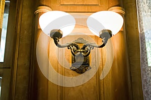 Brass sconces on a wooden wall