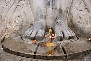 Brass statue infront of a gigiantic monolithic statue of Bahubali, also known as Gomateshwara, Vindhyagiri Hill, Shravanbelgola photo