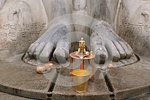 Brass statue infront of a gigiantic monolithic statue of Bahubali, also known as Gomateshwara, Vindhyagiri Hill, Shravanbelgola photo