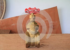 brass valve with red knob in a factory plumber on wooden floor