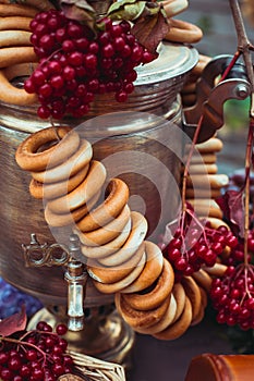 Brass vintage samovar, a bundle of bagels, red berries as a symbol of Russian hospitality