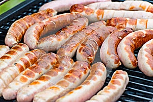 Brat sausage are on the charcoal grill