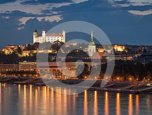 Bratislava castle at night with light reflection on the dunaj ri