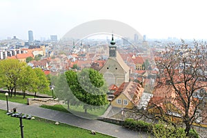 Bratislava, Slovensko - apríl, 2011: park so zelenými stromami, chrám sv. Mikuláša a výhľad na staré mesto z kopca bratislavského hradu