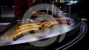 Bratwurst Sausage Grilling On A Streetfood Cart In Downtown Vienna At Night, Austria