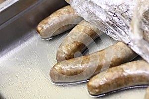 Bratwurst sausages warming in a pan