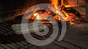 bratwurst white German sausage. cooking in the fireplace or barbecue two bratwurst engraved with the background of a