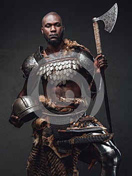 Brave african soldier from the past looking at camera holding an axe
