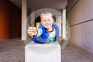 Brave boy with gesture of impetuousness and empowerment playing in the city