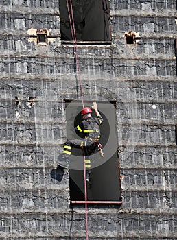 brave climber of firefighters rappelling the wall