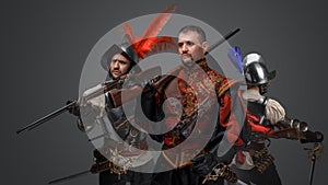 Brave conquistador with two soldiers against gray background