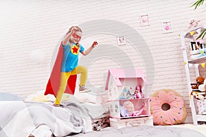 Brave cute little girl jumps out of bed, imagining flight