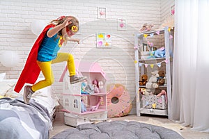 Brave cute little girl jumps out of bed, imagining flight