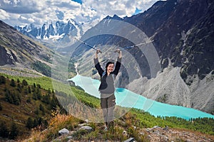 Brave girl conquering mountain peaks of the Altai mountains. The majestic nature of the mountain peaks and lakes. Hiking