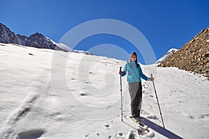 Brave girl conquering mountain peaks of the Altai mountains. The majestic nature of the mountain peaks and lakes. Hiking