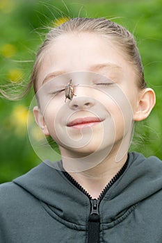 Cockchafer sits on the girl`s face photo