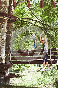 Brave little girl in the forest adventure park