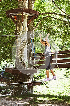 Brave little girl in the forest adventure park