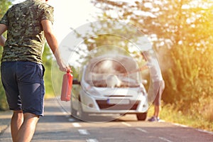 Brave man with fire extinguisher going to a car incident on the