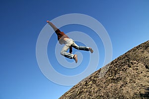 Brave man jumping from a cliff