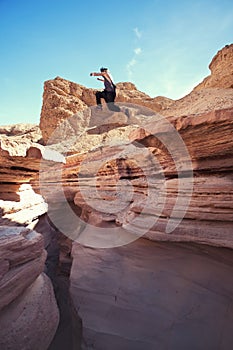 Brave man jumping over the cliff in canyon