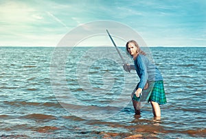 Brave man with sword in scottish costume