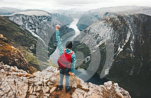 Brave Man traveling in Norway mountains standing on cliff