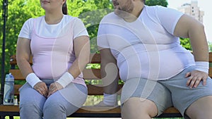 Brave obese man sitting near chubby girl in park and trying to get acquainted