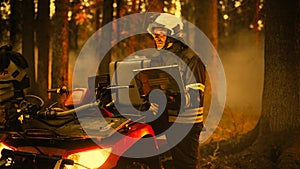 Brave Skillful Firefighter Standing Next to an ATV, Using Laptop Computer in Forest with Raging