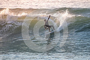 Brave teenager making tricks on the rough sea