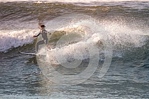 Brave teenager making tricks on the rough sea