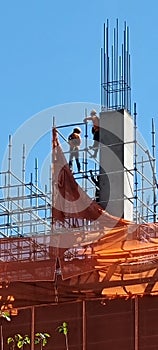Brave workers standing around ten storeys up in the air in Bangkok photo